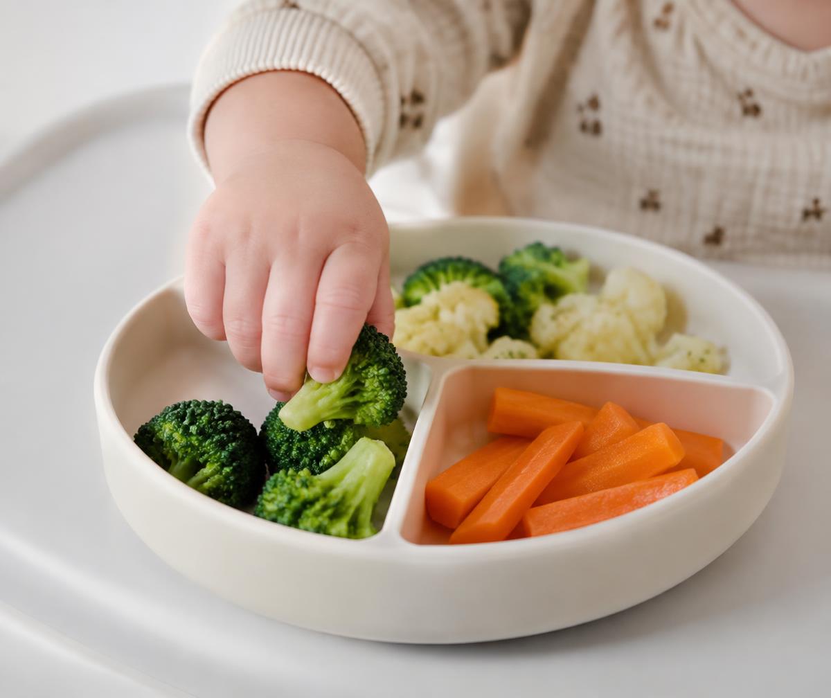 Barn smager på en broccoli